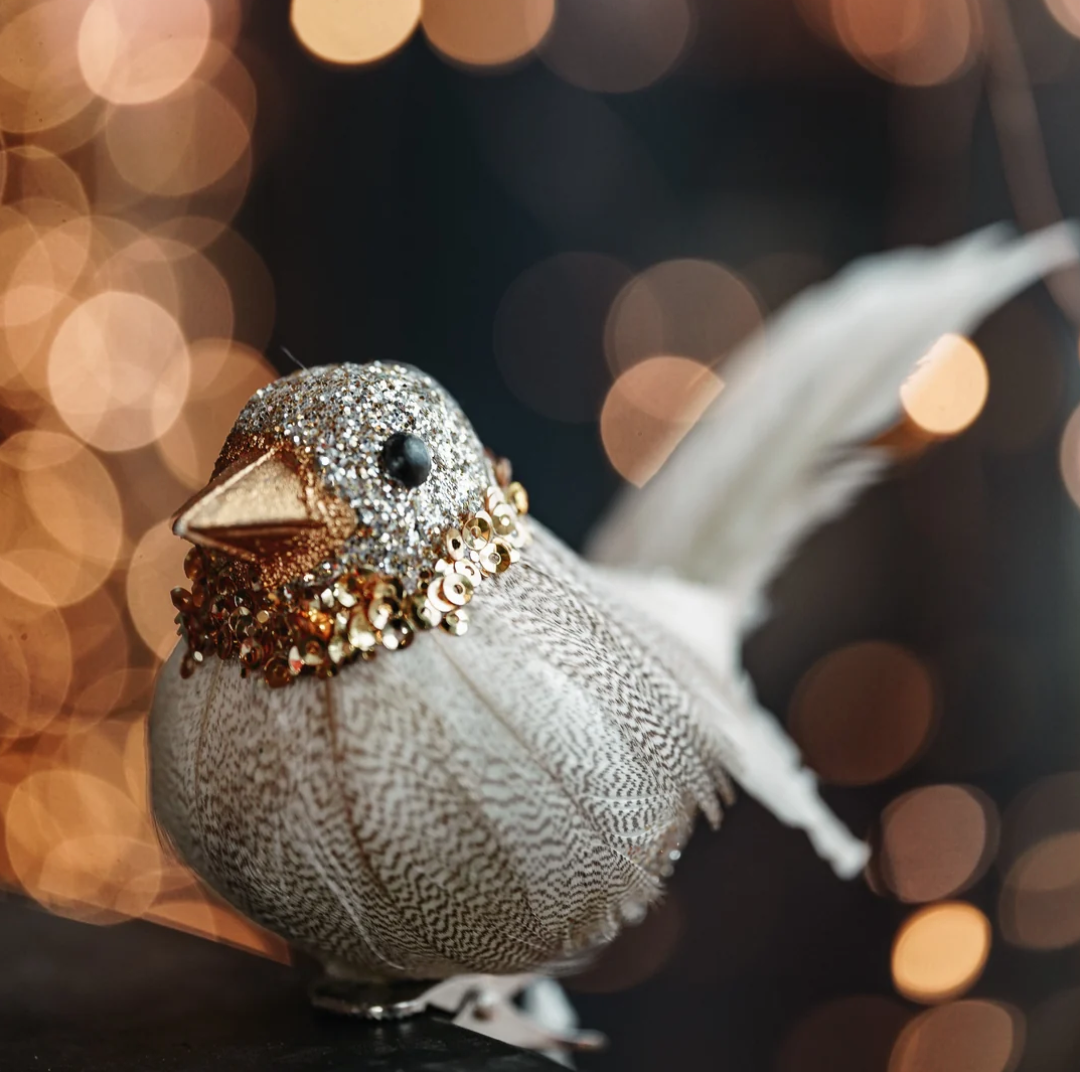Pajarito decorativo con detalles brillantes en tonos dorado y plateado