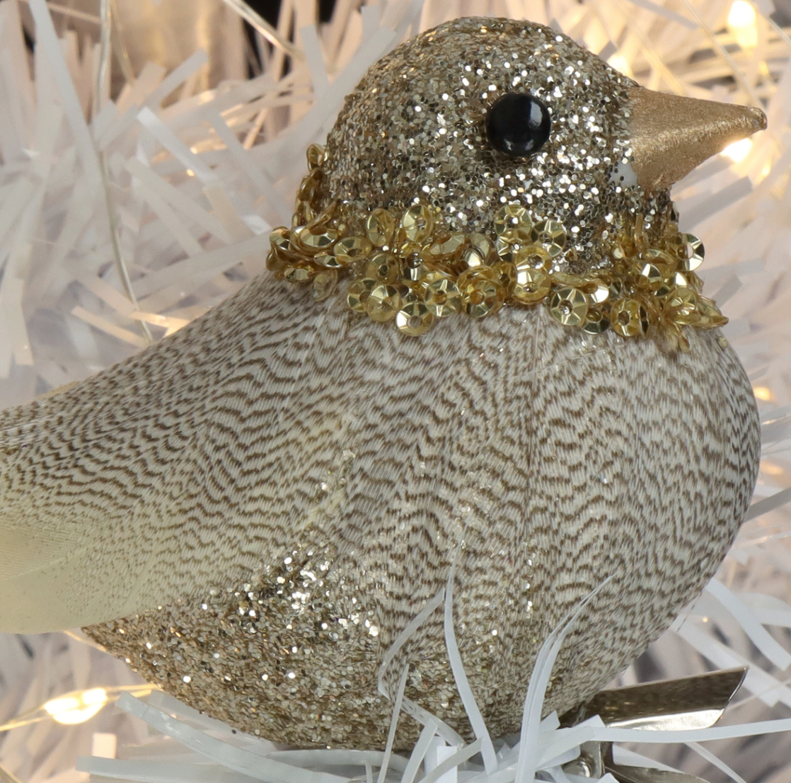 Pajarito decorativo con detalles brillantes en tonos dorado y plateado