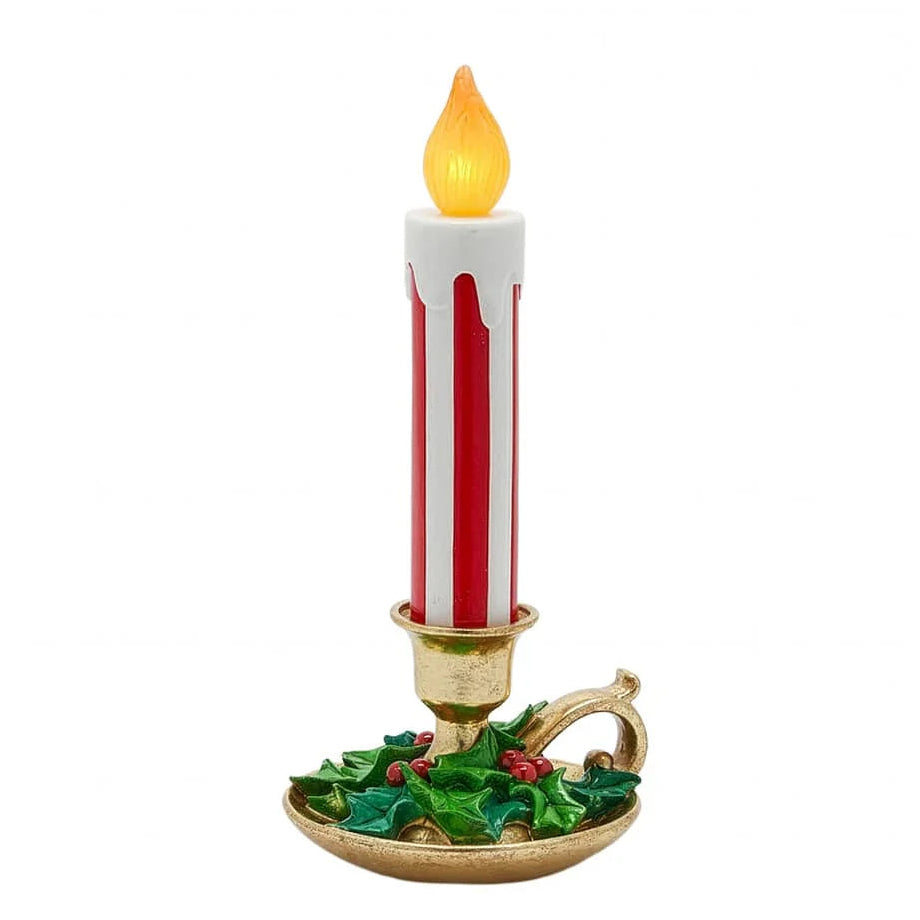 Vela decorativa navideña con base dorada y acebo