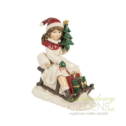Figura navideña niña en trineo con regalos y árbol